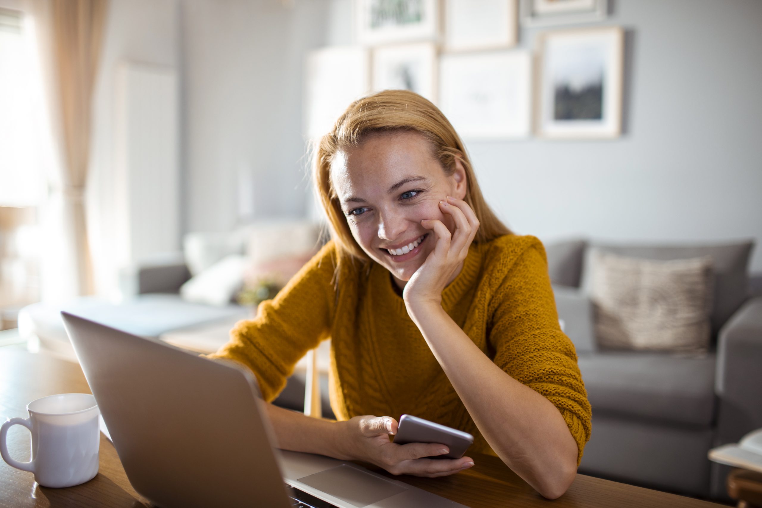 Young Woman using a Phone while having Breakfast in the Morning